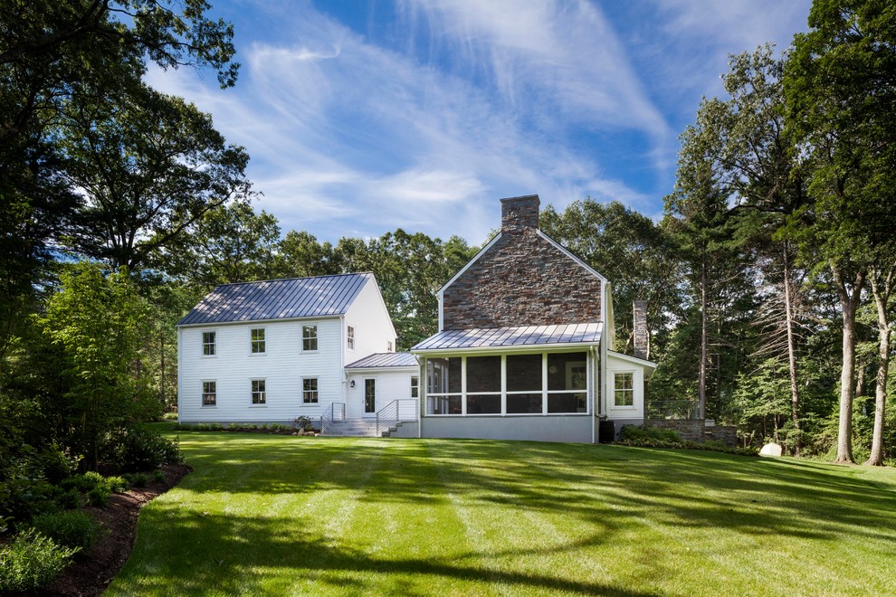 Large farmhouse white two-story stone exterior home photo in Boston
