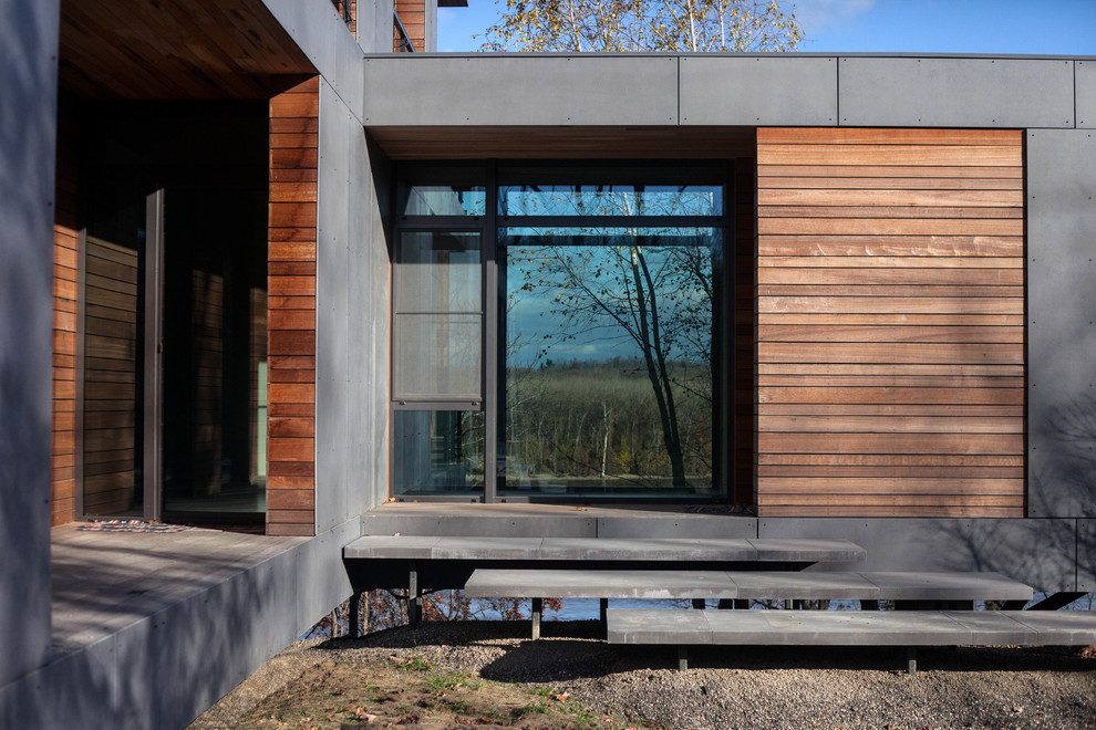 Esempio della facciata di una casa contemporanea con rivestimento in legno e abbinamento di colori