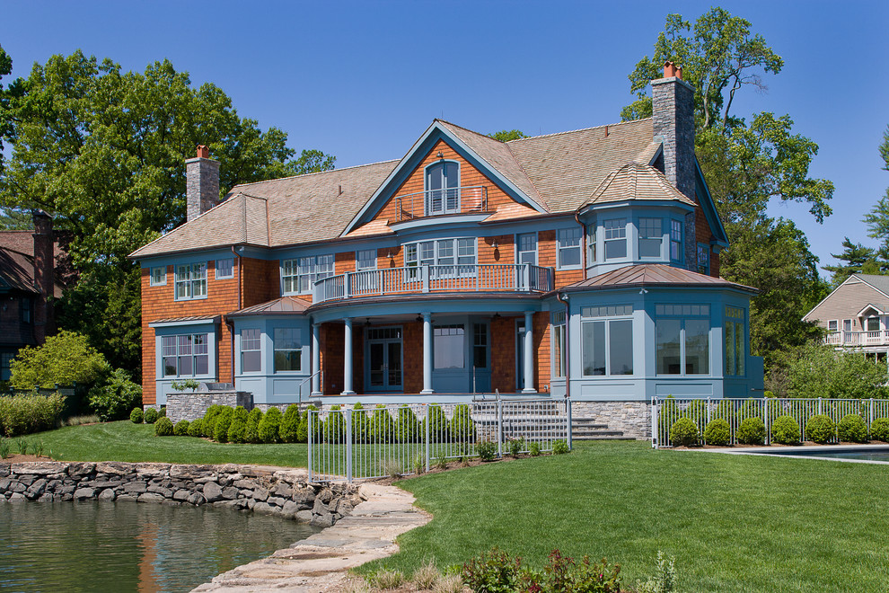 Foto della facciata di una casa grande blu vittoriana a tre piani con rivestimento in legno e tetto a capanna
