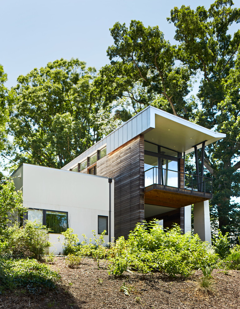 Inspiration för mellanstora moderna flerfärgade hus, med två våningar, pulpettak och tak i metall