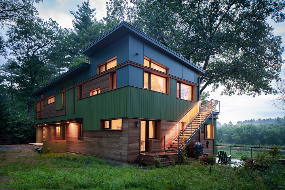 Cette image montre une grande façade de maison multicolore design à deux étages et plus avec un revêtement mixte et un toit en appentis.