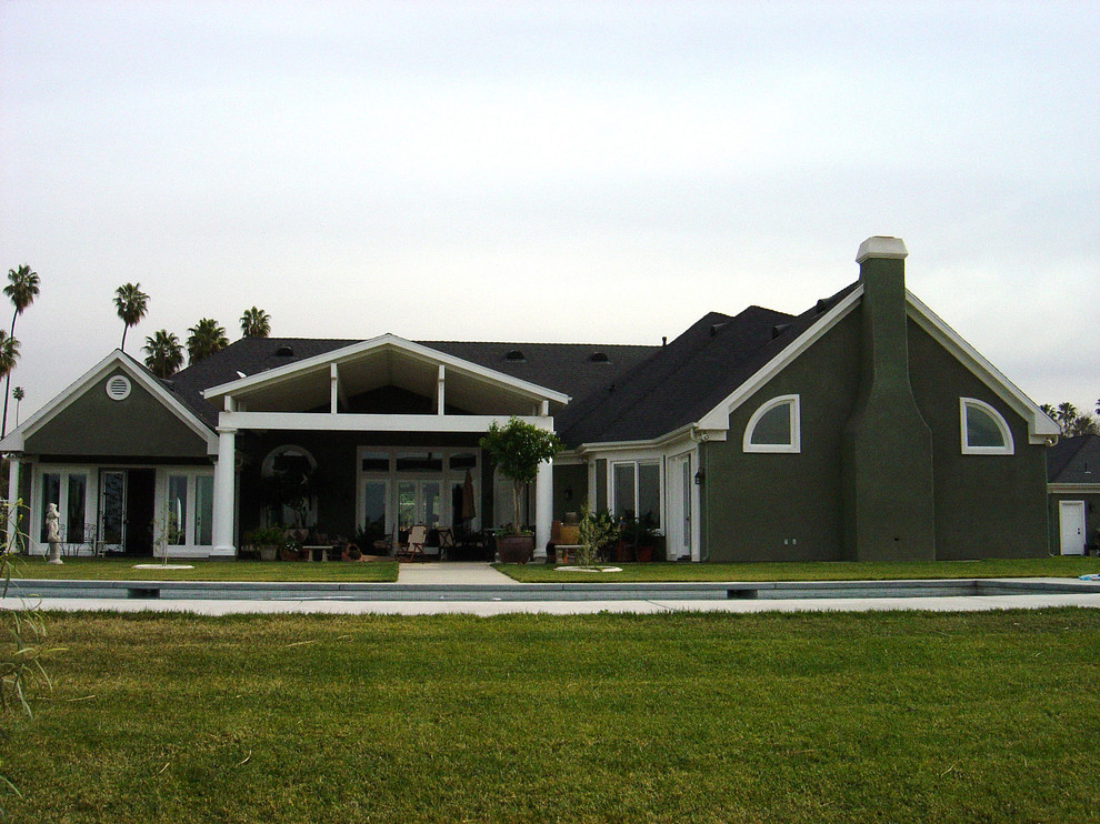 Cette photo montre une grande façade de maison verte tendance en stuc de plain-pied.
