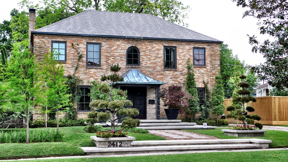 Elegant brick exterior home photo in Houston with a hip roof