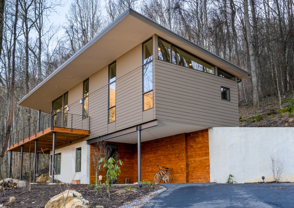 Aménagement d'une grande façade de maison multicolore contemporaine à un étage avec un revêtement mixte et un toit plat.