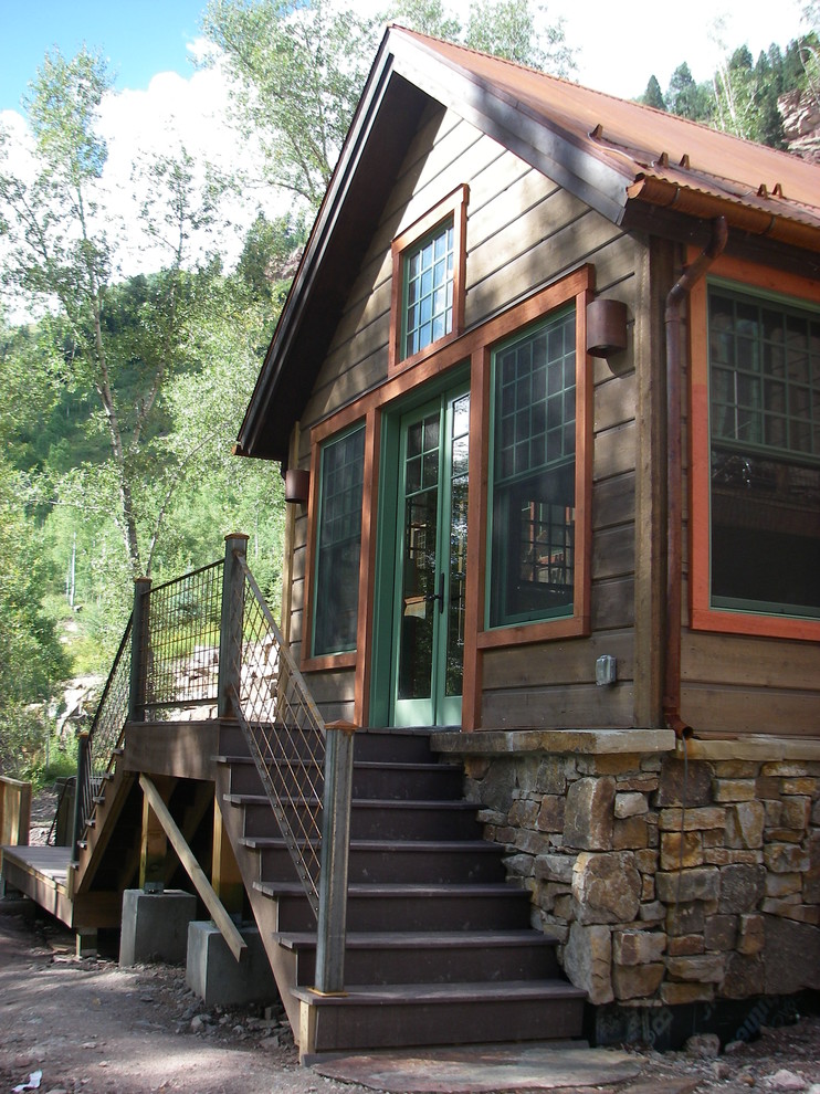 Ispirazione per la facciata di una casa piccola marrone rustica a due piani con rivestimenti misti e tetto a capanna