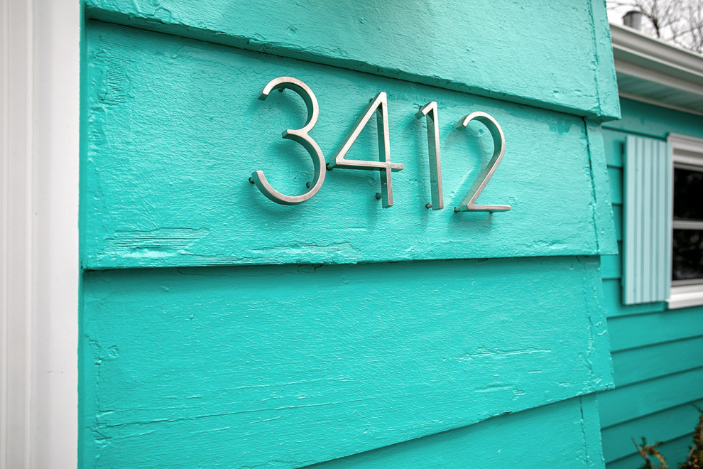 На фото: одноэтажный, синий частный загородный дом среднего размера в стиле ретро