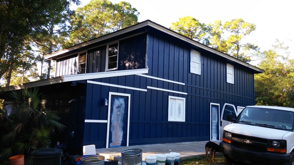 Inspiration for a large country blue two-story wood exterior home remodel in Miami with a shed roof