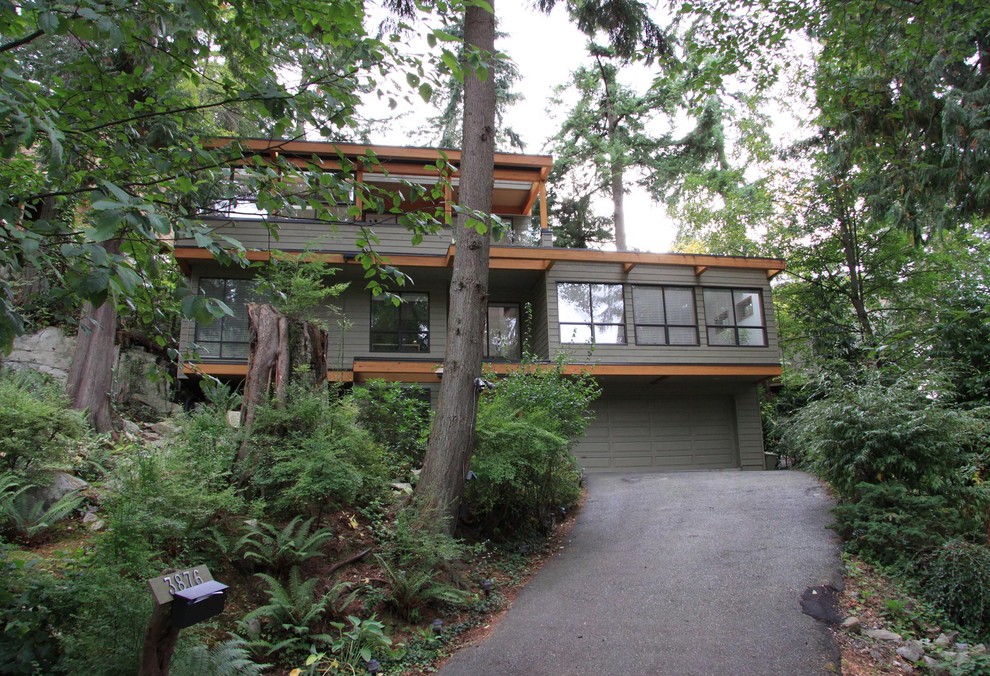 Modelo de fachada de casa verde contemporánea de tamaño medio de dos plantas con revestimiento de madera y tejado plano