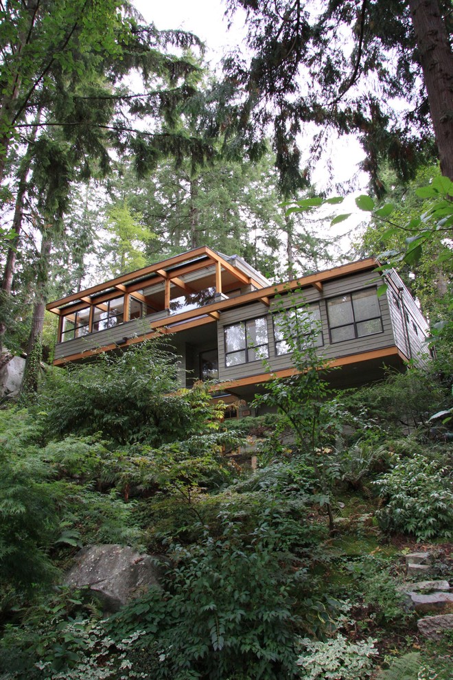This is an example of a medium sized and green contemporary two floor detached house in Vancouver with wood cladding and a mixed material roof.