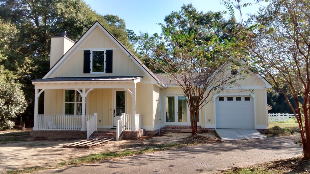 Kleines Country Haus mit Faserzement-Fassade und gelber Fassadenfarbe in Sonstige