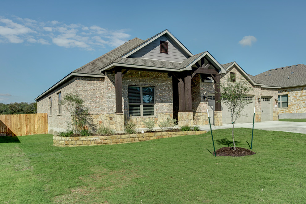 Large arts and crafts gray one-story brick house exterior photo in Austin with a hip roof and a mixed material roof