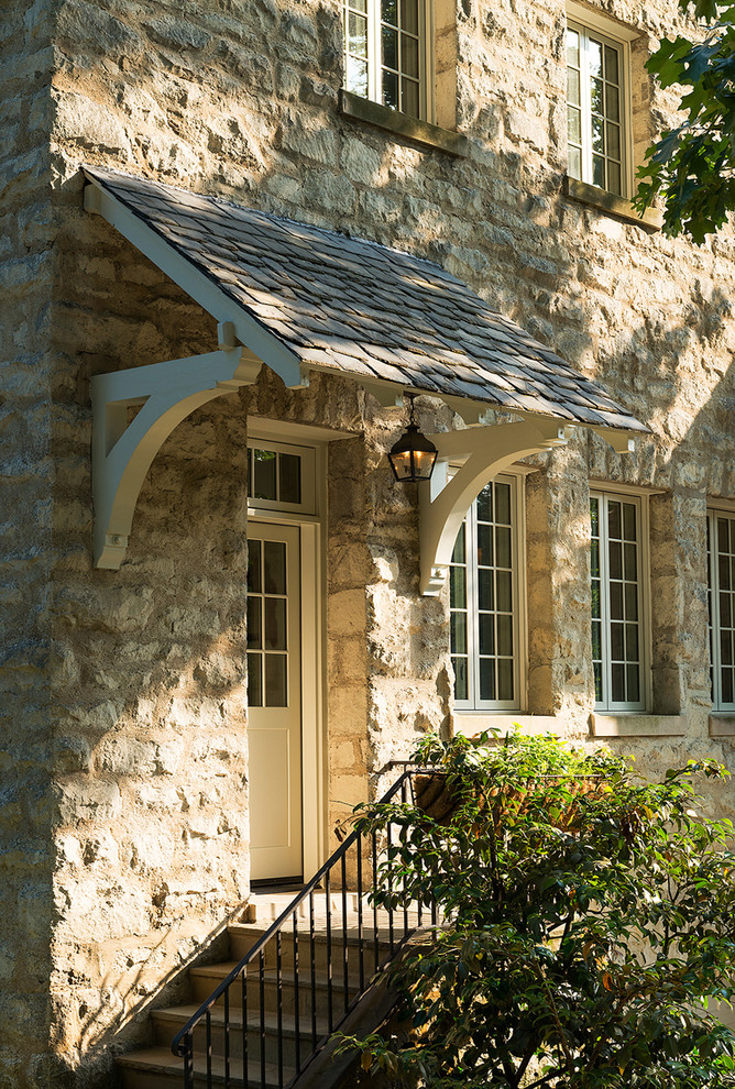 Ispirazione per la facciata di una casa beige classica a tre piani con rivestimento in pietra
