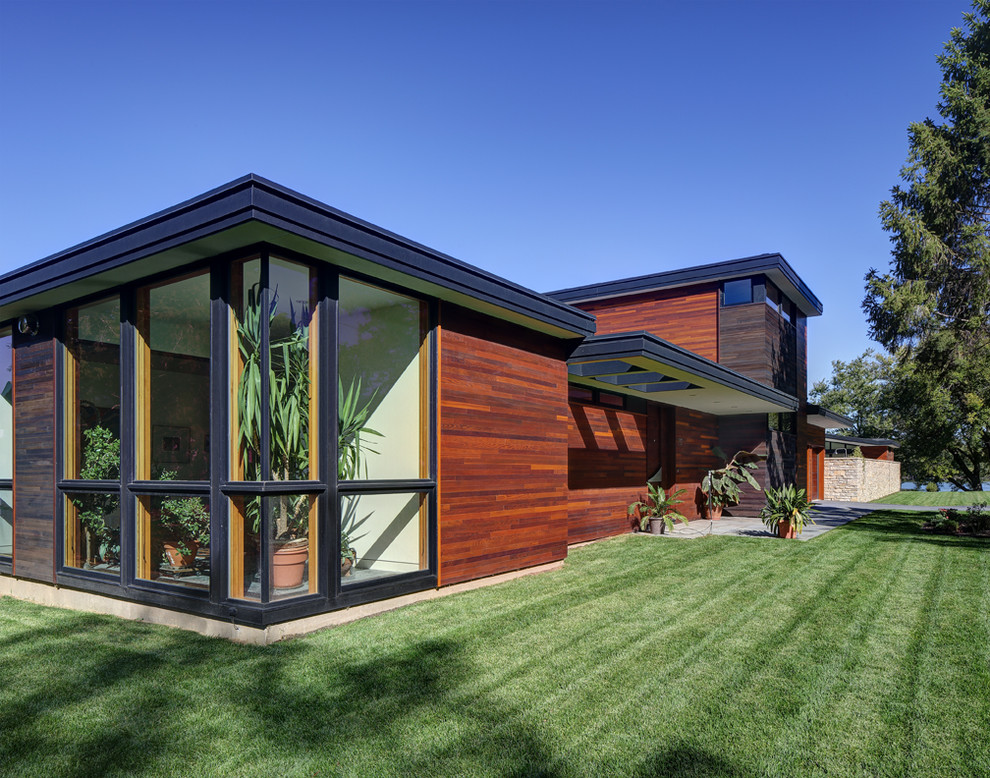 Ejemplo de fachada de casa minimalista de tamaño medio de dos plantas con revestimientos combinados y tejado plano