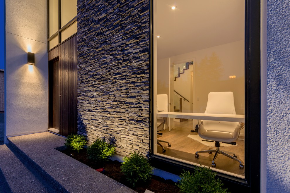 Diseño de fachada gris contemporánea de dos plantas con revestimientos combinados y tejado plano