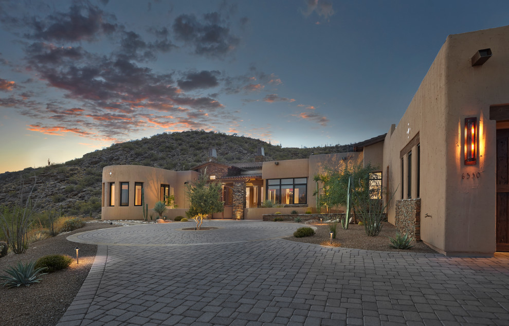 Large southwest brown one-story stucco exterior home photo in Phoenix