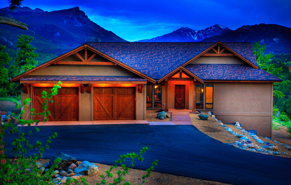 Large mountain style brown two-story stucco exterior home photo in Denver with a shingle roof