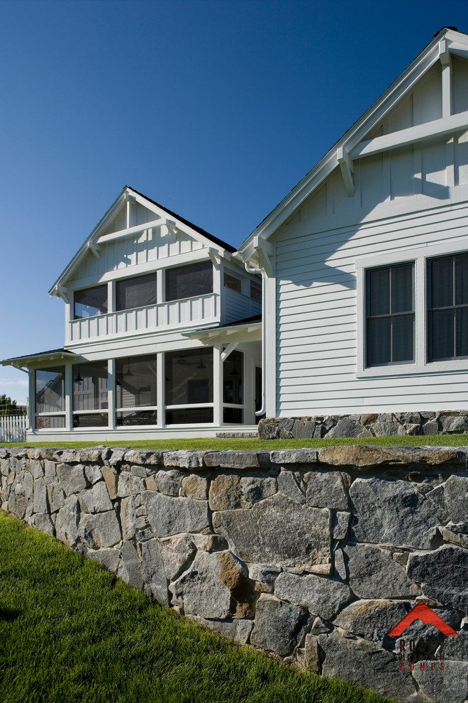 Modelo de fachada blanca de estilo de casa de campo grande de tres plantas con revestimiento de madera