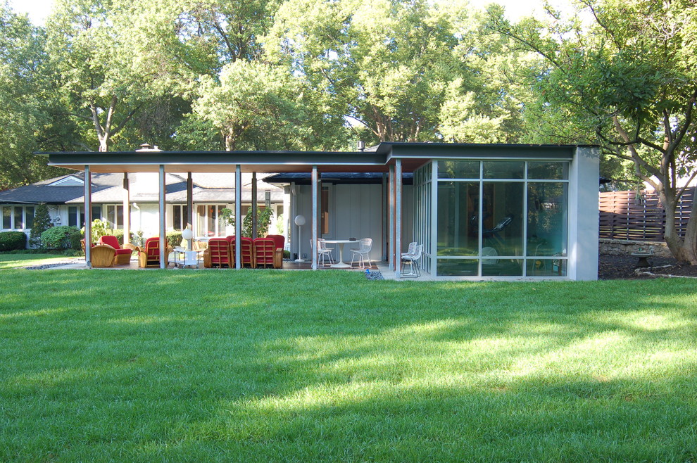 Example of a mid-century modern glass exterior home design in Kansas City
