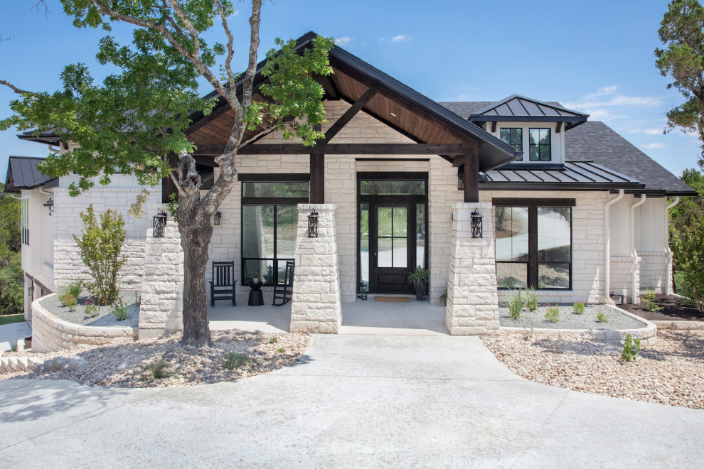 Large elegant white two-story stone exterior home photo in Austin with a mixed material roof