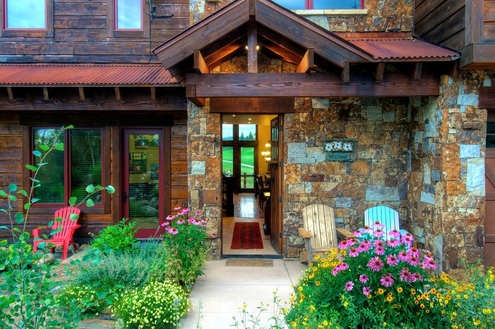 Large elegant brown three-story stone gable roof photo in Denver