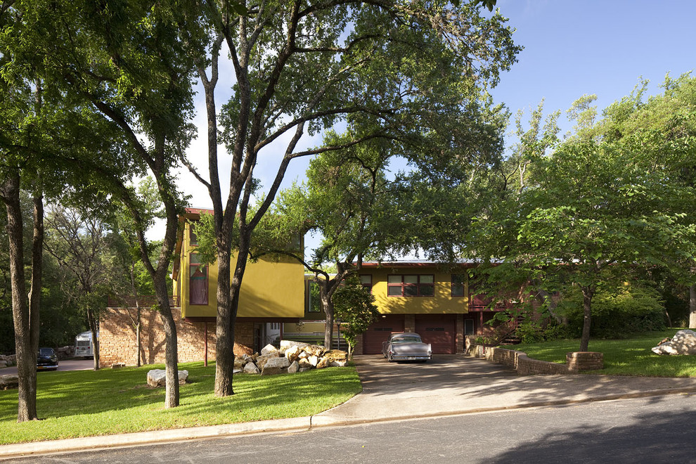 Geräumiges, Zweistöckiges Modernes Haus mit Mix-Fassade, gelber Fassadenfarbe und Halbwalmdach in Austin