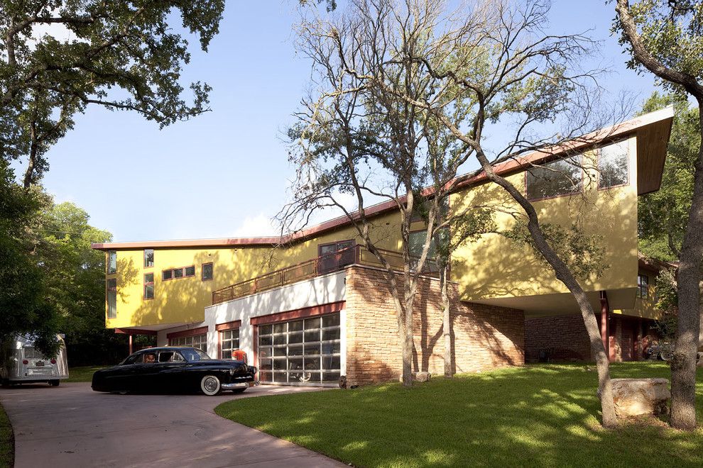 Geräumiges, Zweistöckiges Modernes Haus mit Mix-Fassade, gelber Fassadenfarbe und Halbwalmdach in Austin