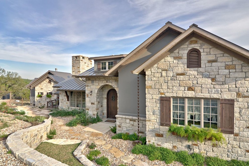 Large cottage one-story stone exterior home photo in Austin
