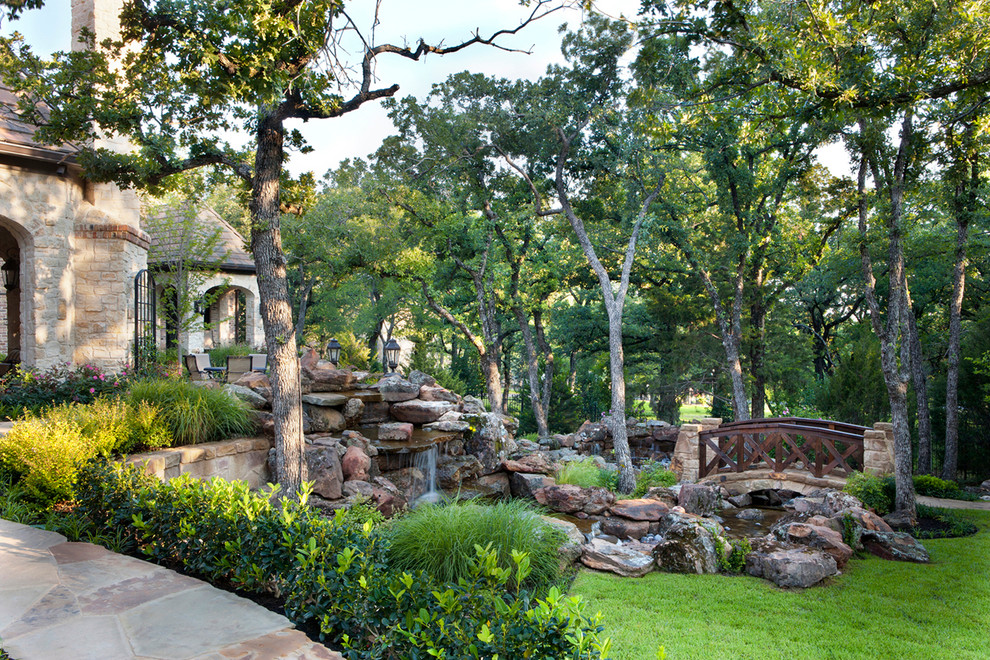 Example of a large mountain style beige one-story stone exterior home design in Dallas with a hip roof