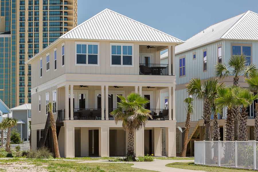 Foto della facciata di una casa grande beige stile marinaro a tre piani con rivestimento in legno