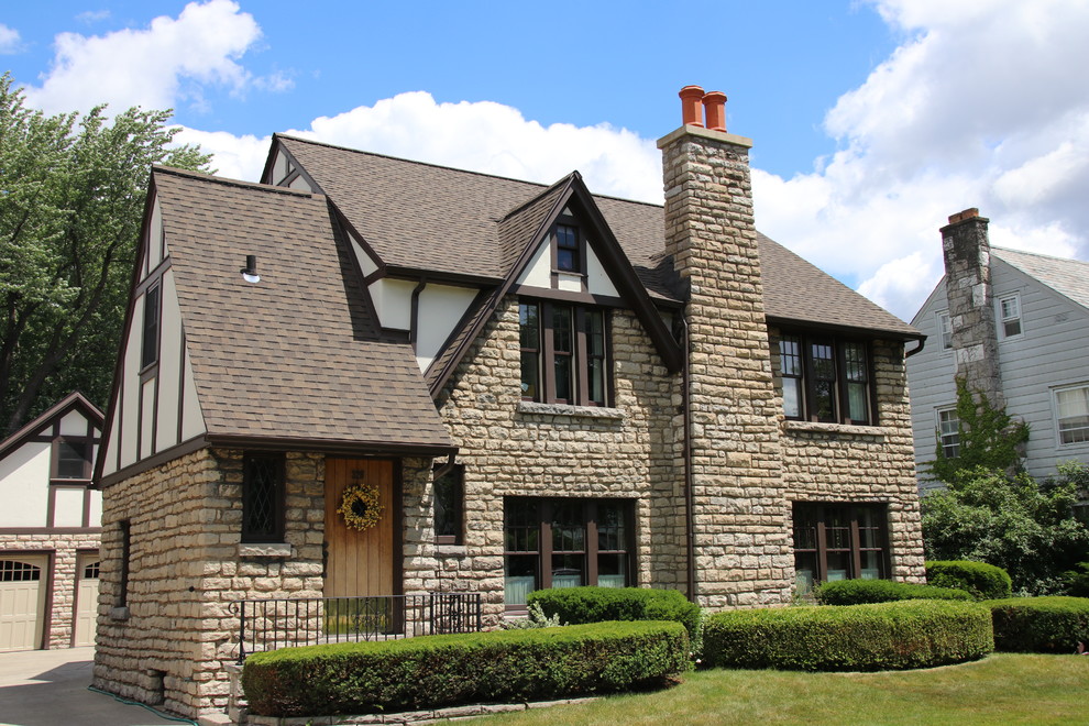 Diseño de fachada de casa beige clásica de dos plantas con revestimientos combinados, tejado a dos aguas y tejado de teja de madera