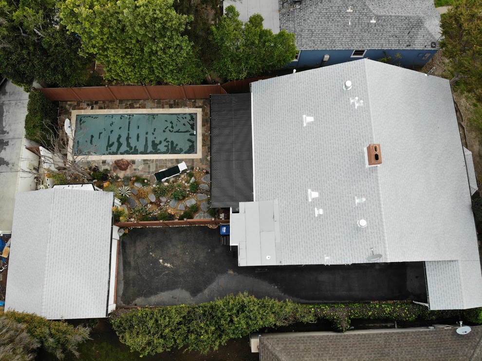 Cette image montre une façade de maison sud-ouest américain de taille moyenne et de plain-pied avec un toit à deux pans et un toit en shingle.