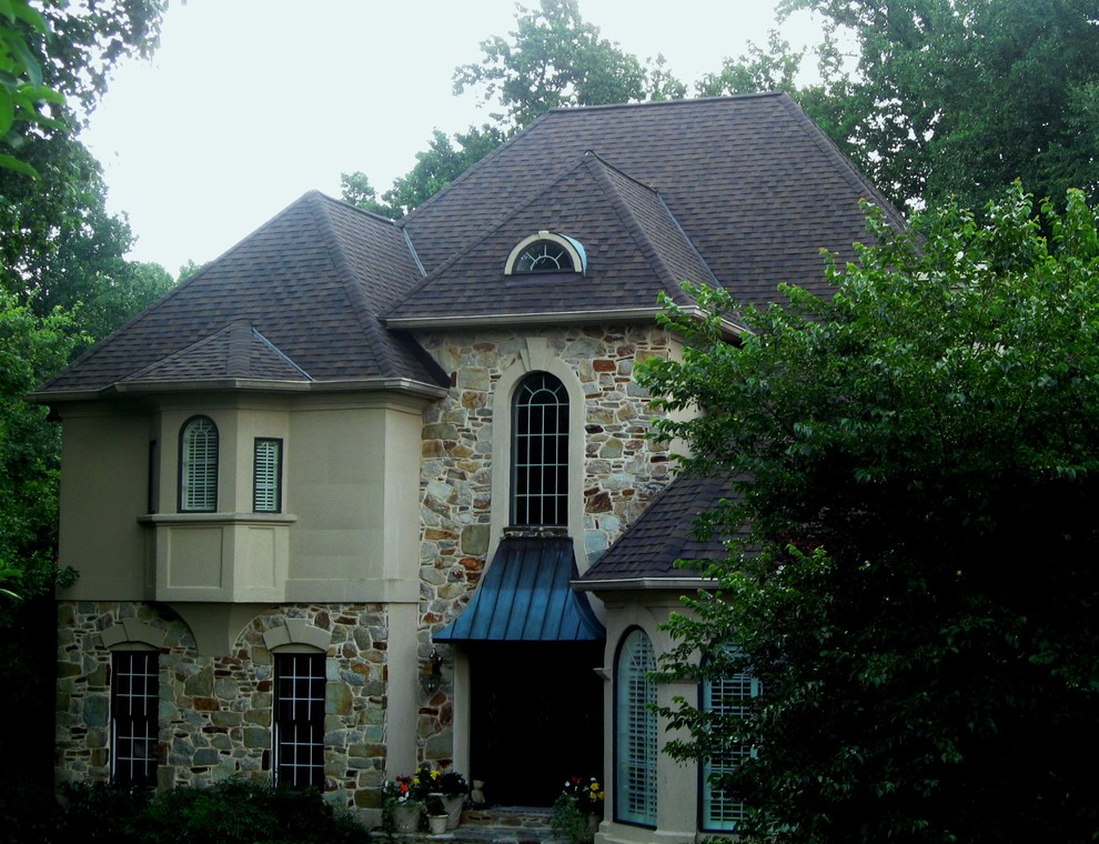 Aménagement d'une grande façade de maison rouge victorienne en brique à un étage avec un toit à quatre pans.