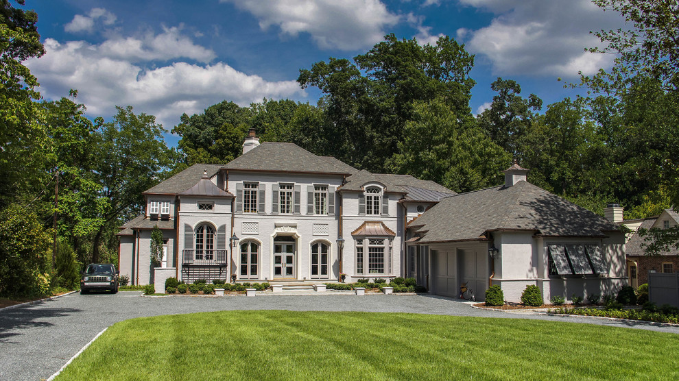 Inspiration for a huge eclectic beige two-story stucco gable roof remodel in Charlotte