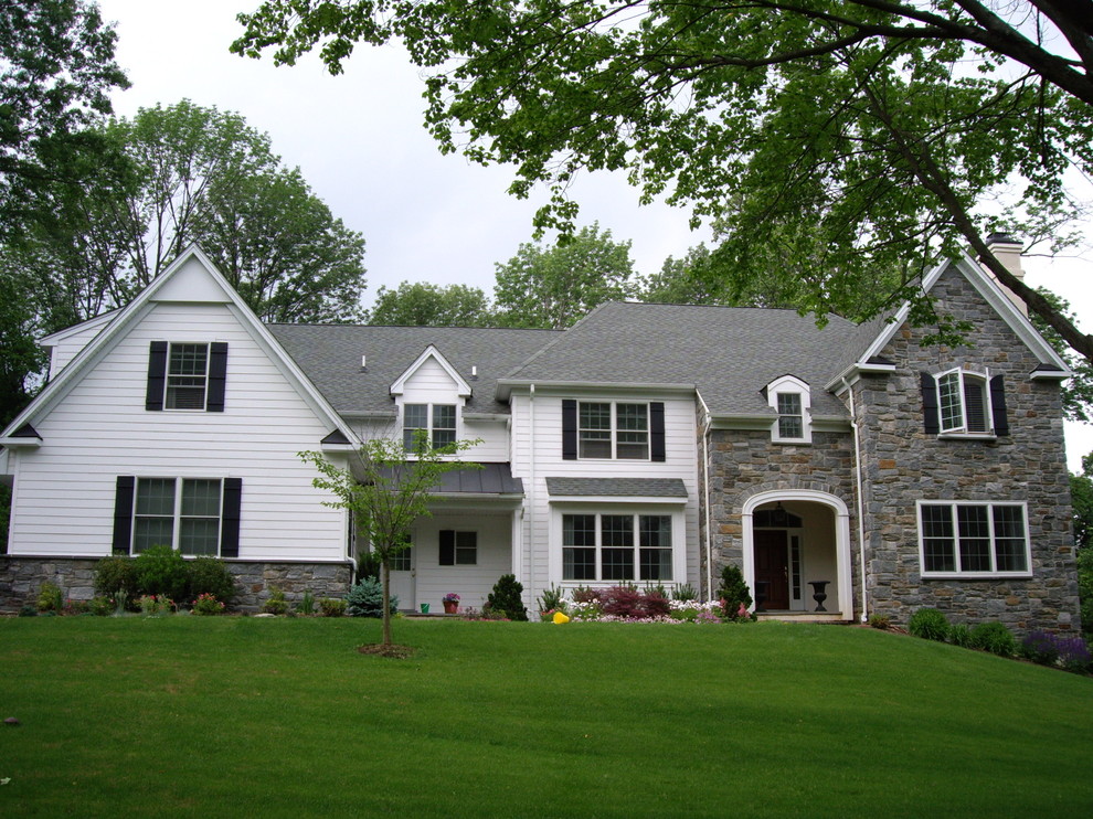 Пример оригинального дизайна: двухэтажный, белый частный загородный дом в классическом стиле с комбинированной облицовкой и двускатной крышей