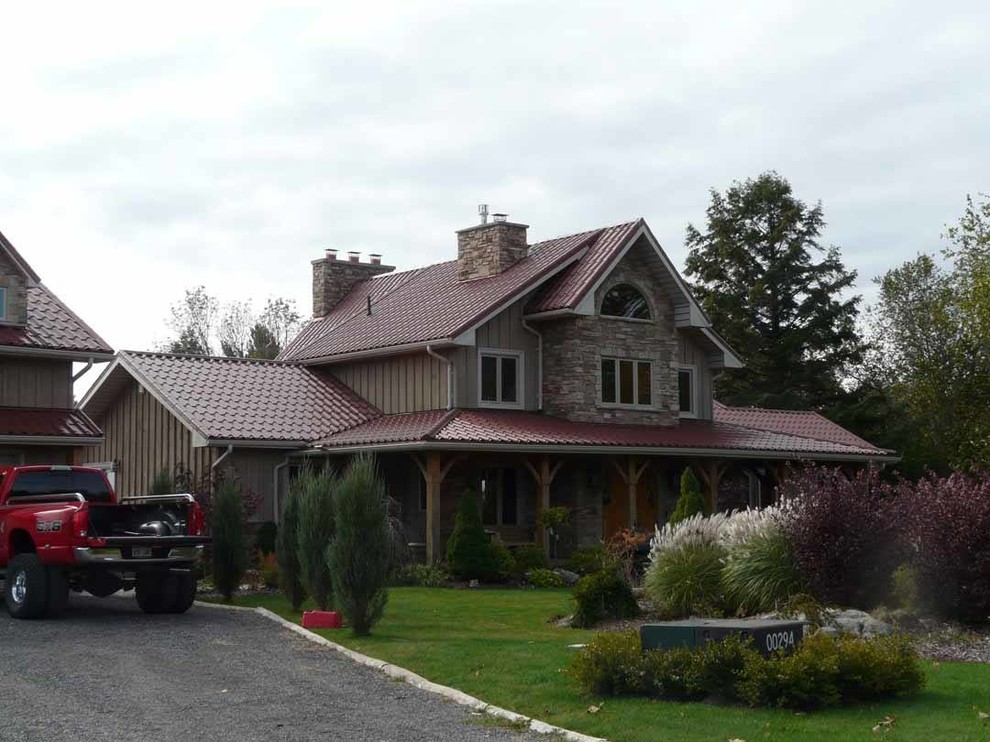 Medium sized and gey mediterranean two floor detached house in Toronto with stone cladding, a pitched roof and a tiled roof.