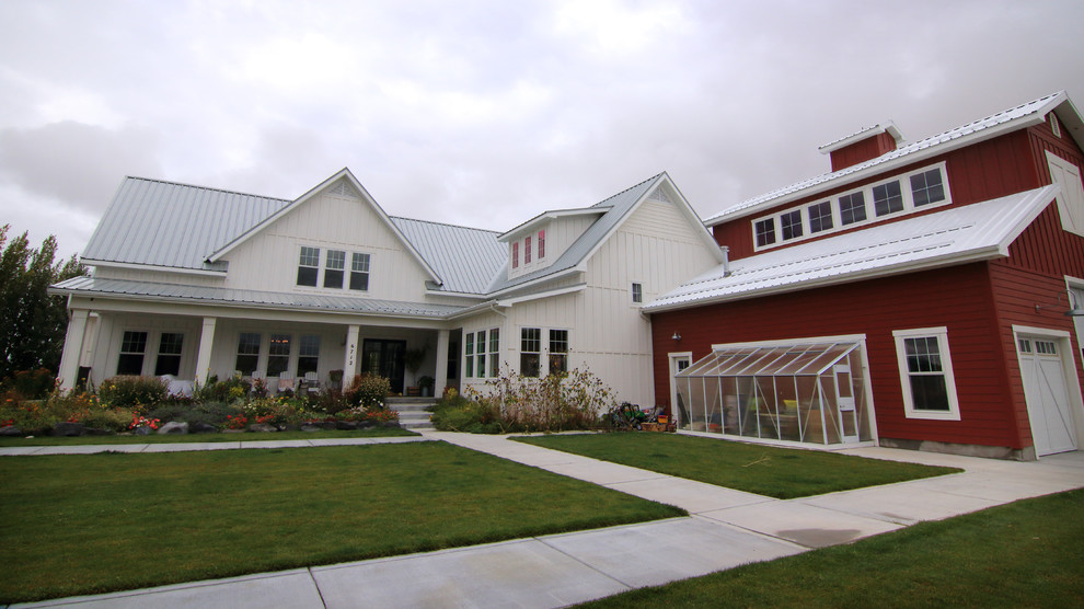 Стильный дизайн: двухэтажный, красный частный загородный дом среднего размера в стиле рустика с облицовкой из металла, односкатной крышей и металлической крышей - последний тренд