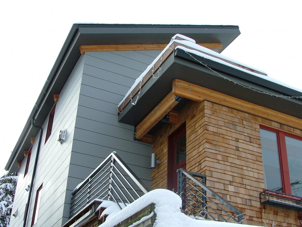 Mittelgroßes, Dreistöckiges Modernes Haus mit Metallfassade, grüner Fassadenfarbe und Pultdach in Seattle