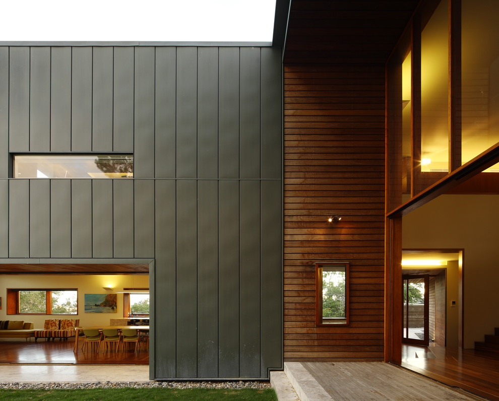 Réalisation d'une très grande façade de maison métallique et grise design à deux étages et plus avec un toit plat.