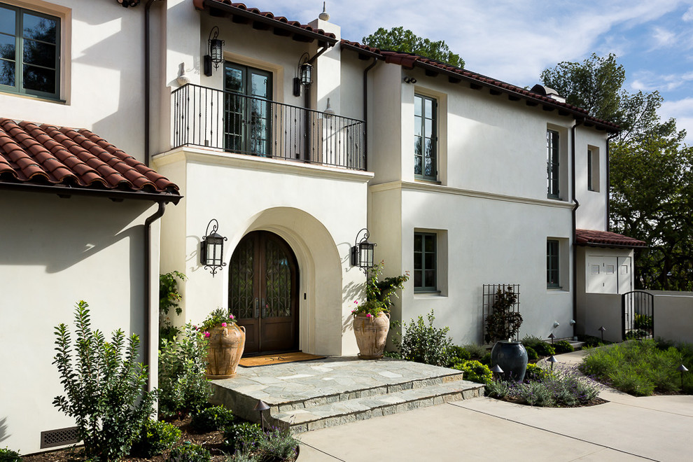 Photo of a beige mediterranean two floor render detached house in Los Angeles with a tiled roof.