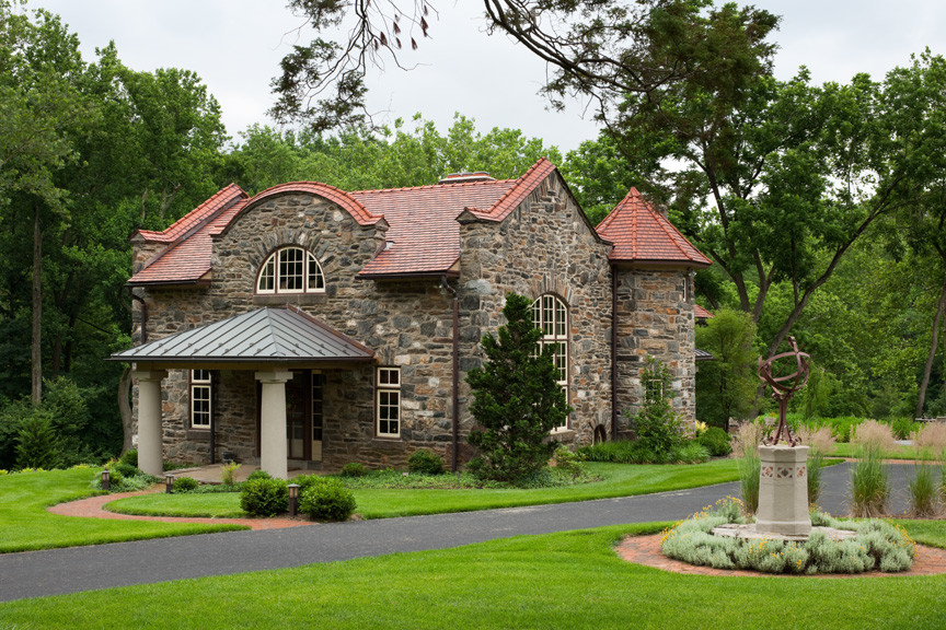 Cette photo montre une façade de maison marron chic en pierre de taille moyenne et à un étage avec un toit à deux pans.