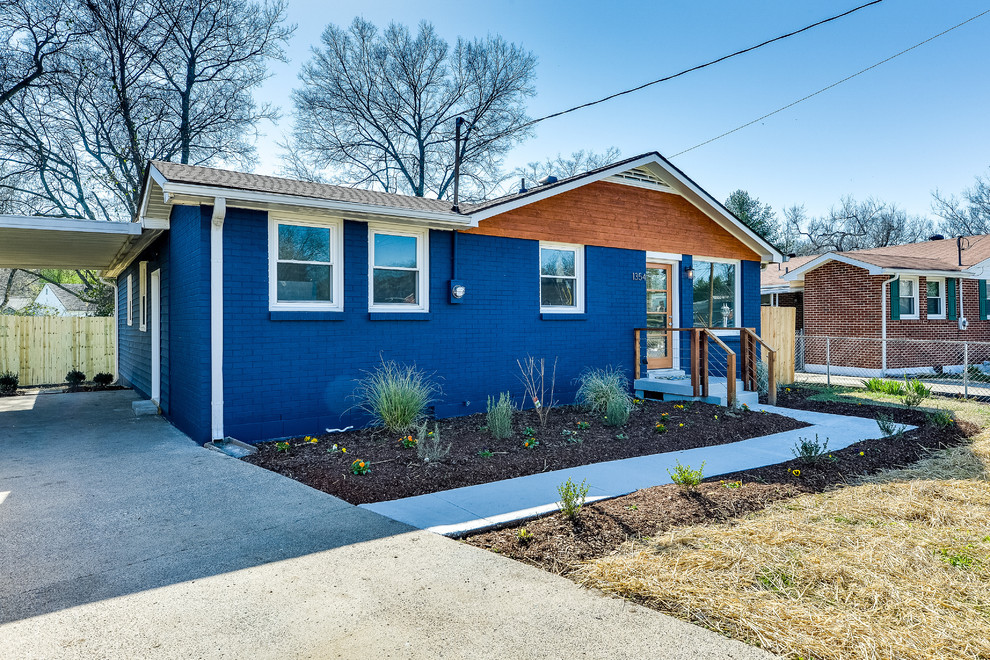 Foto de fachada de casa azul actual de tamaño medio de una planta con revestimiento de ladrillo, tejado a dos aguas y tejado de teja de madera