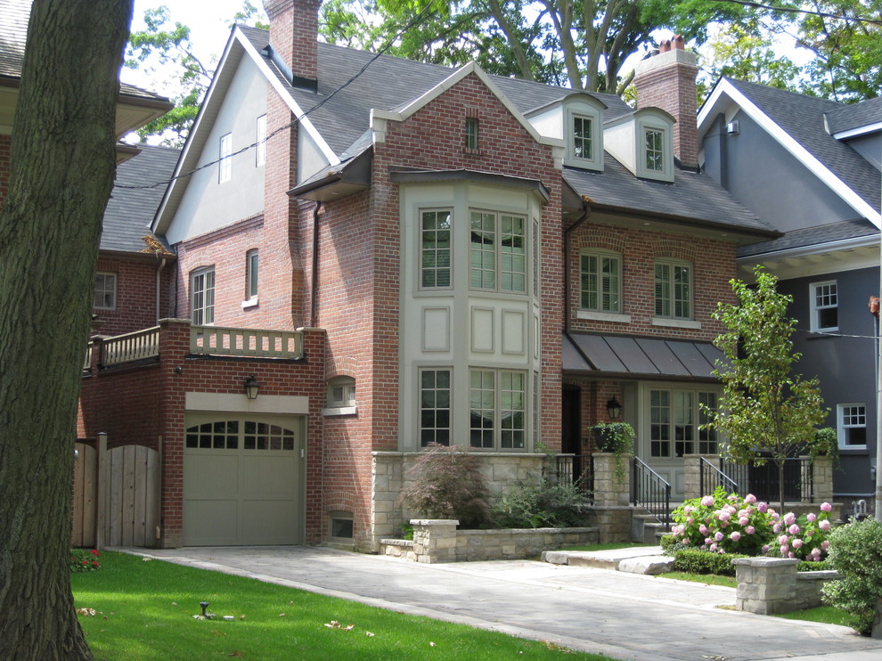 Aménagement d'une grande façade de maison rouge classique en brique à deux étages et plus avec un toit en shingle et un toit à quatre pans.