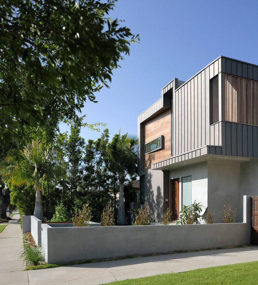 Modelo de fachada de casa gris actual grande de dos plantas con revestimientos combinados, tejado plano y tejado de metal