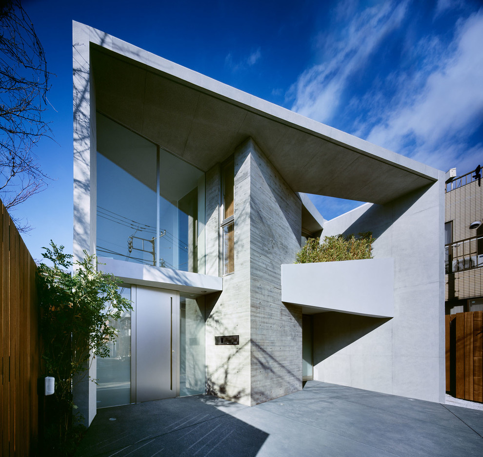 Esempio della facciata di una casa grigia contemporanea a due piani con rivestimento in cemento e tetto piano