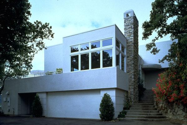 Foto på ett stort funkis grått hus, med två våningar, stuckatur och platt tak