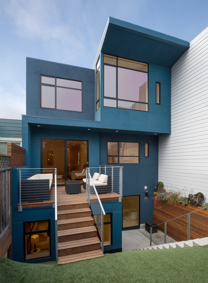 Idee per la facciata di una casa blu contemporanea a tre piani con terreno in pendenza