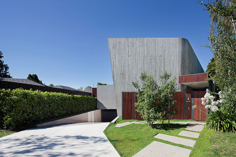 Großes, Dreistöckiges Modernes Haus mit Betonfassade, Flachdach und grauer Fassadenfarbe in Melbourne