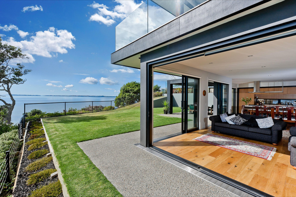 Mittelgroßes Modernes Haus mit Mix-Fassade, brauner Fassadenfarbe und Flachdach in Auckland