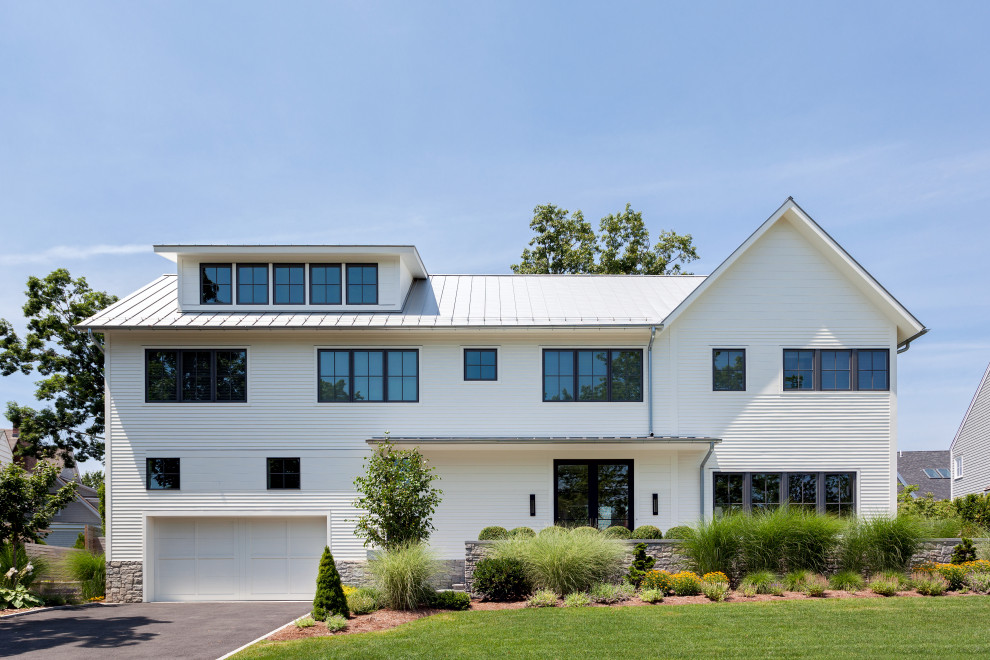 Modelo de fachada de casa blanca nórdica de tamaño medio de dos plantas con tejado a dos aguas, tejado de metal y revestimiento de madera