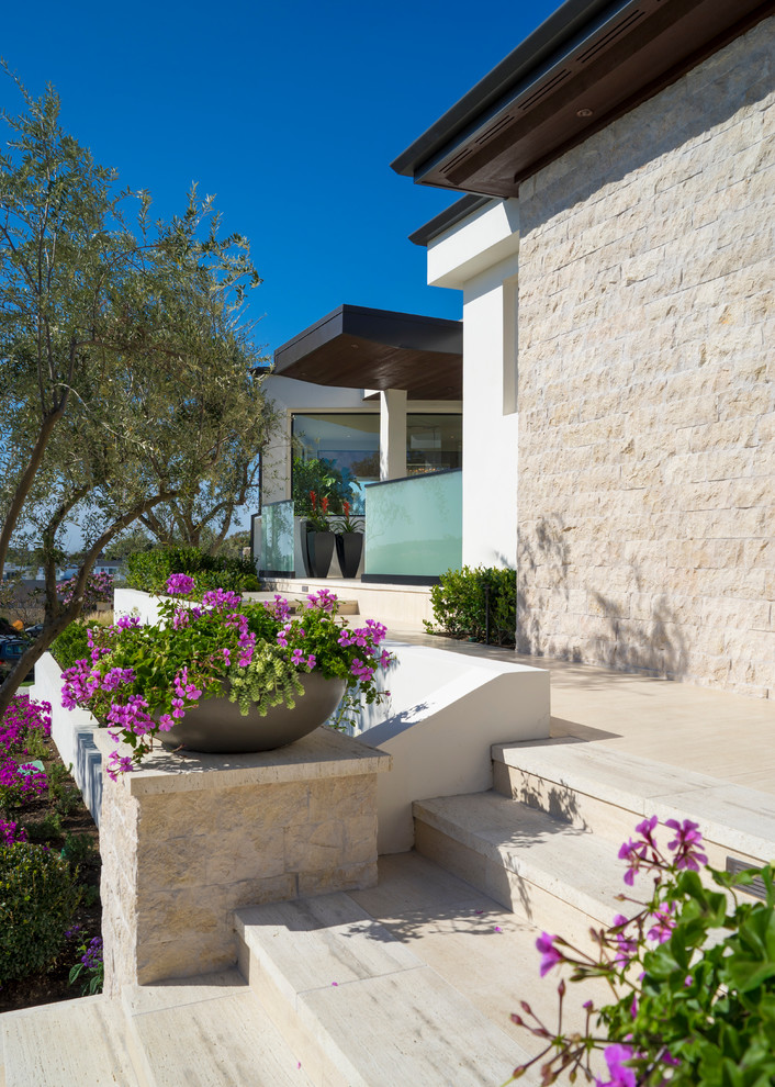 Exemple d'une grande façade de maison blanche tendance en stuc à un étage avec un toit plat.